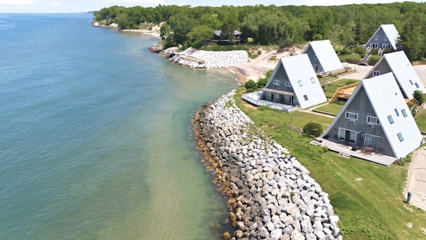 Une propriété située sur la côte, comprenant des maisons, un rivage rocheux et offrant une vue dégagée sur la mer.