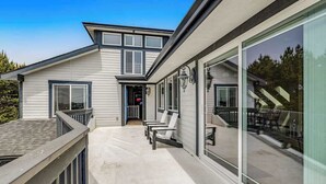 A modern two-story house with a covered porch, large windows, and a visible staircase.