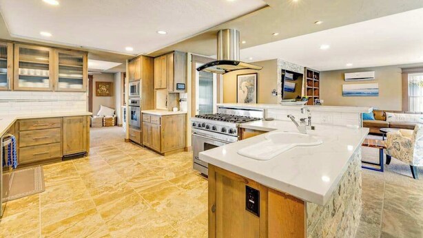A spacious kitchen with a central island, built-in appliances, and a dining area with a view.