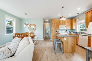 Une cuisine moderne avec des meubles en bois, un îlot central et un coin repas comprenant un canapé et des chaises.