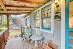 A wooden deck with a chair, a small table, and a wicker basket. - Dog-friendly house near the beach and promenade with electric fireplace (Seaside)