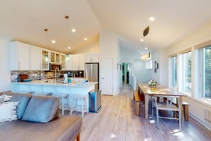 A modern kitchen with a central island, wooden flooring, and pendant lighting. - Luxe townhome with amazing ocean & mountain views - walk to beach & downtown (Manzanita)