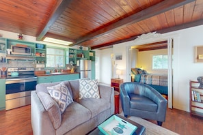 A cozy living room with a sofa, armchair, and a coffee table.