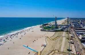 Una spiaggia con una montagna russa, una battigia sabbiosa e un lungomare con edifici.