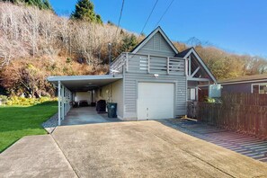 Une maison de plain-pied avec un garage, une véranda et une allée menant au garage.