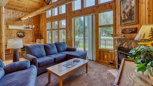 A wooden interior with a sofa, coffee table, and fireplace.