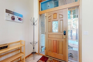 A wooden door with a glass panel, a coat rack, and a bench. - Elegant home with pool, private hot tub, game room, deck & SHARC passes (Sunriver)