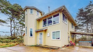 A two-story house with a covered porch, a hot tub, and a garage.