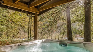 A hot tub with a view of a forested area. - Spacious riverfront lodge with beach access, private hot tub & forest views (Washougal)