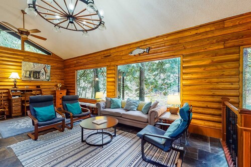 Spacious riverfront lodge with beach access, private hot tub & forest views