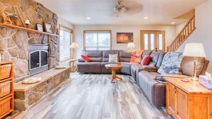 A living room with a stone fireplace, a sectional sofa, and a wooden coffee table. - Dog-friendly house near the beach with spectacular views and pool table (Seaside)