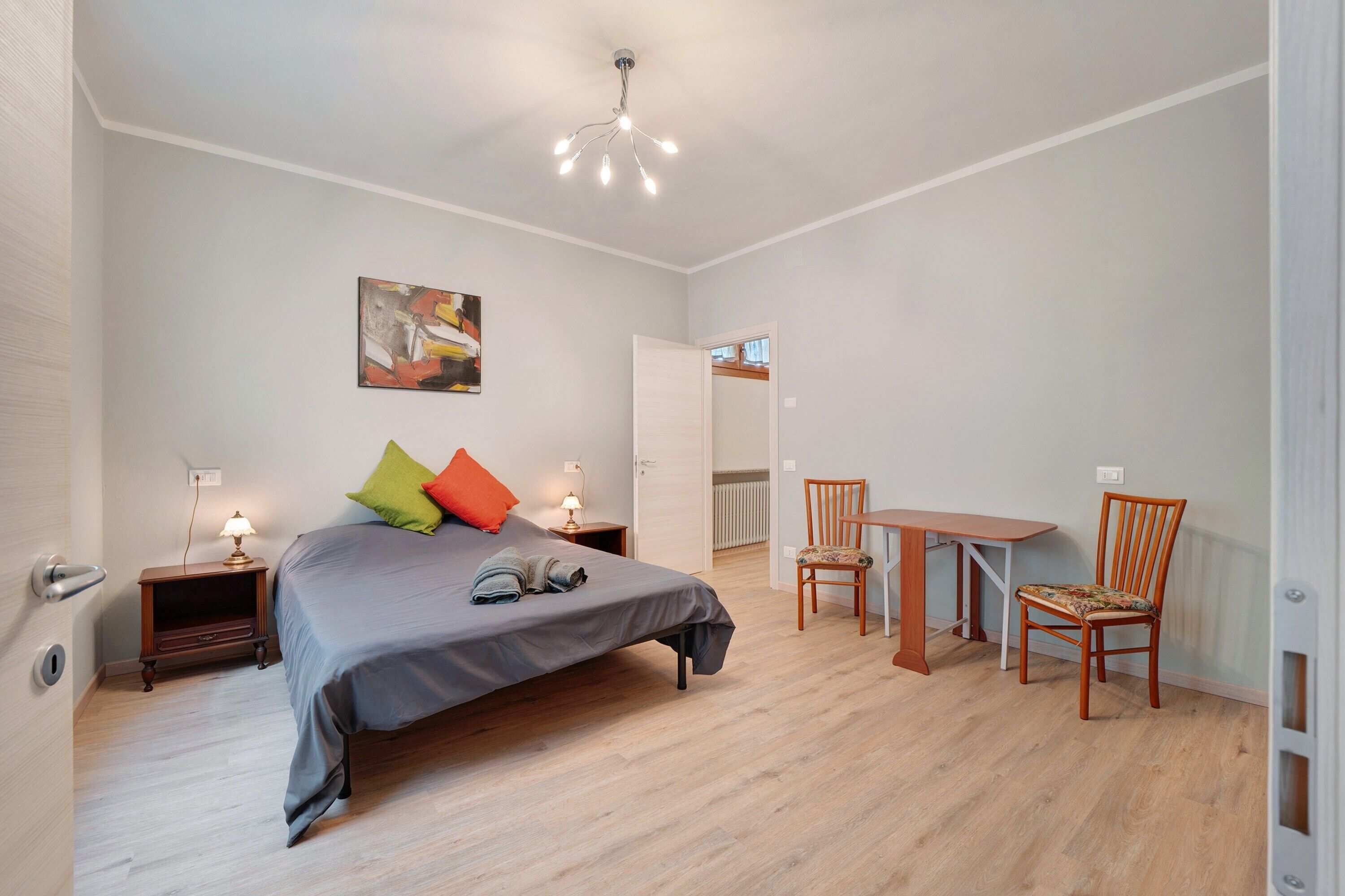 Ein Schlafzimmer mit einem Bett, Nachttischen, einem Tisch und Stühlen.