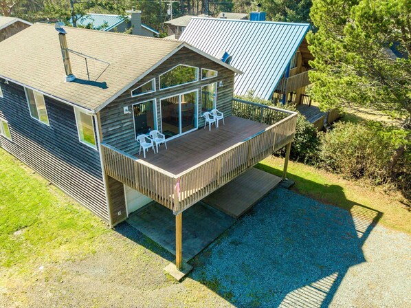 A modern house with a wooden deck, large windows, and a metal roof. - 2-story dog-friendly home with beach access, Ping-Pong table, & grill (Manzanita)