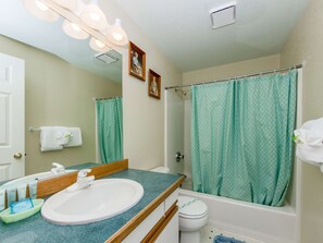 A bathroom with a sink, mirror, shower curtain, and toilet. - 2-story dog-friendly home with beach access, Ping-Pong table, & grill (Manzanita)