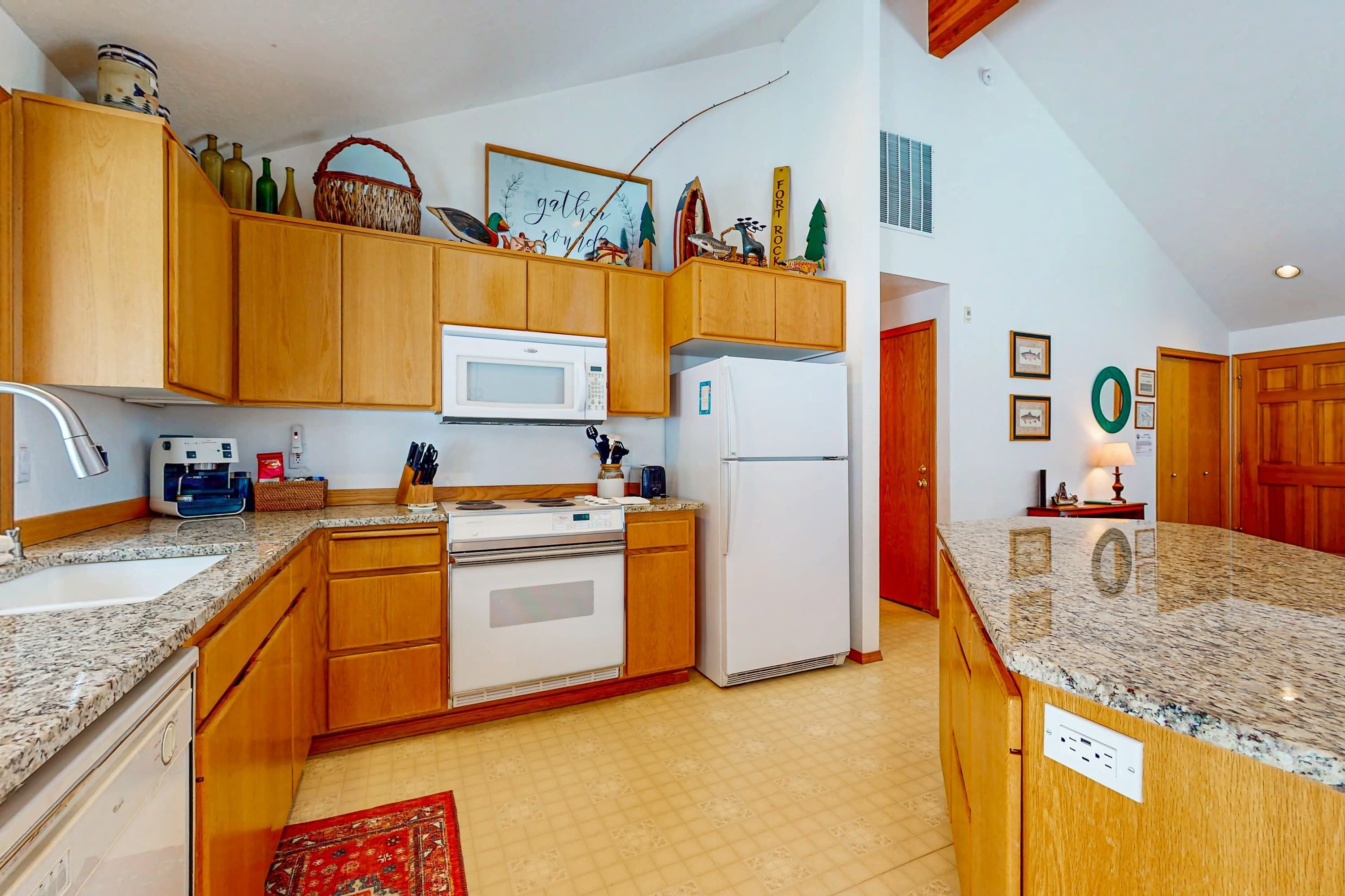 A kitchen with wooden cabinets, a microwave, a refrigerator, a stove, and a sink.