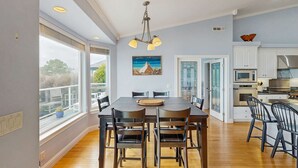 Una cocina moderna con comedor, ventanas amplias y vistas al exterior.