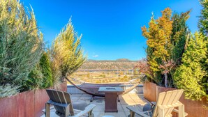 A rooftop terrace with a hammock, two Adirondack chairs, a table, and a view of a distant landscape. - Hood River townhouse close to everything with river-view location & rooftop BBQ (Hood River)