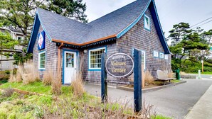 Un bâtiment en bois avec une enseigne indiquant « Centre d’accueil des visiteurs » et une adresse de site web.