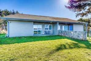 A single-story house with a covered patio area, a front door, and a small front yard.