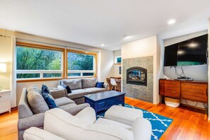 A living room with a fireplace, a television, and a sofa. - Relaxing dog-friendly home with patio & spacious living area MCA #439 (Manzanita)
