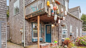 A wooden house with a porch, a blue door, and a sign that reads 'SILVER.'