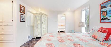 A bedroom with a bed, a wardrobe, a dresser, a mirror, and a window.