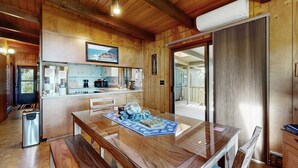 A wooden interior with a dining table, kitchen area, and a view through a glass door. - Unique lakefront cabin near the dunes with a private dock & fireplace (Florence)