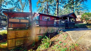 Een chalet met terras, omringd door bomen.