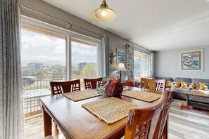 Un comedor con una mesa de madera, sillas y vistas al exterior.