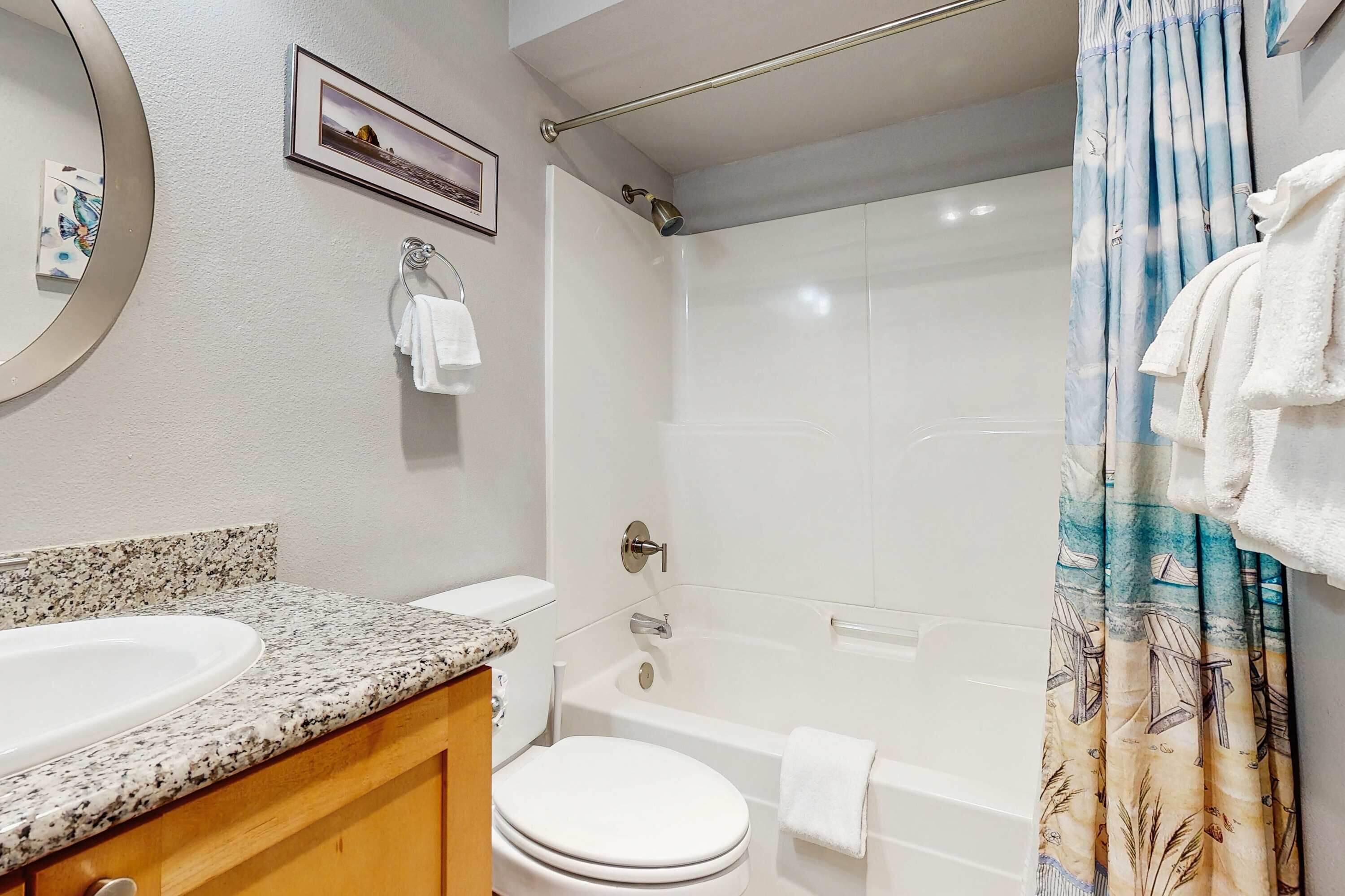 A bathroom with a sink, toilet, bathtub, and shower curtain.
