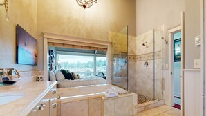 Ein modernes Badezimmer mit Badewanne, Dusche und einer Glaskabine.