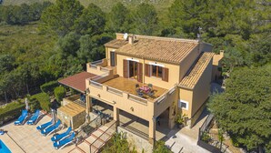 Un bâtiment à deux étages doté d’une terrasse, d’une piscine et surplombant un paysage montagneux.