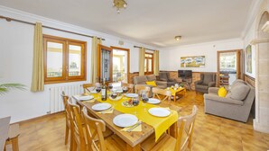 Un coin repas avec une table en bois, dressée pour quatre personnes, entourée de chaises.