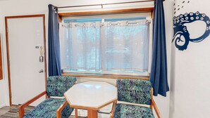 A room with a window, a door, a table, and two patterned chairs. - Cute beach room with fast WiFI - walk to downtown shops & eats (Bandon)
