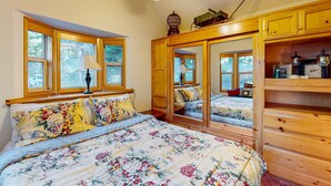 Ein Schlafzimmer mit einem großen Bett, einem Holzschrank und einem Schminktisch.