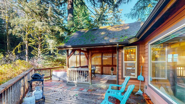 Eine Holzhütte mit Veranda, einer überdachten Sitzgelegenheit und einem großen Fenster.