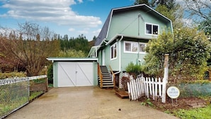 A two-story house with a garage, a staircase, and a fenced yard.