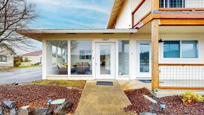 A two-story house with a covered porch, a number '1567' on the front door, and a driveway leading to the entrance. - Cozy condo with sun room, washer & dryer, close to the river (Florence)