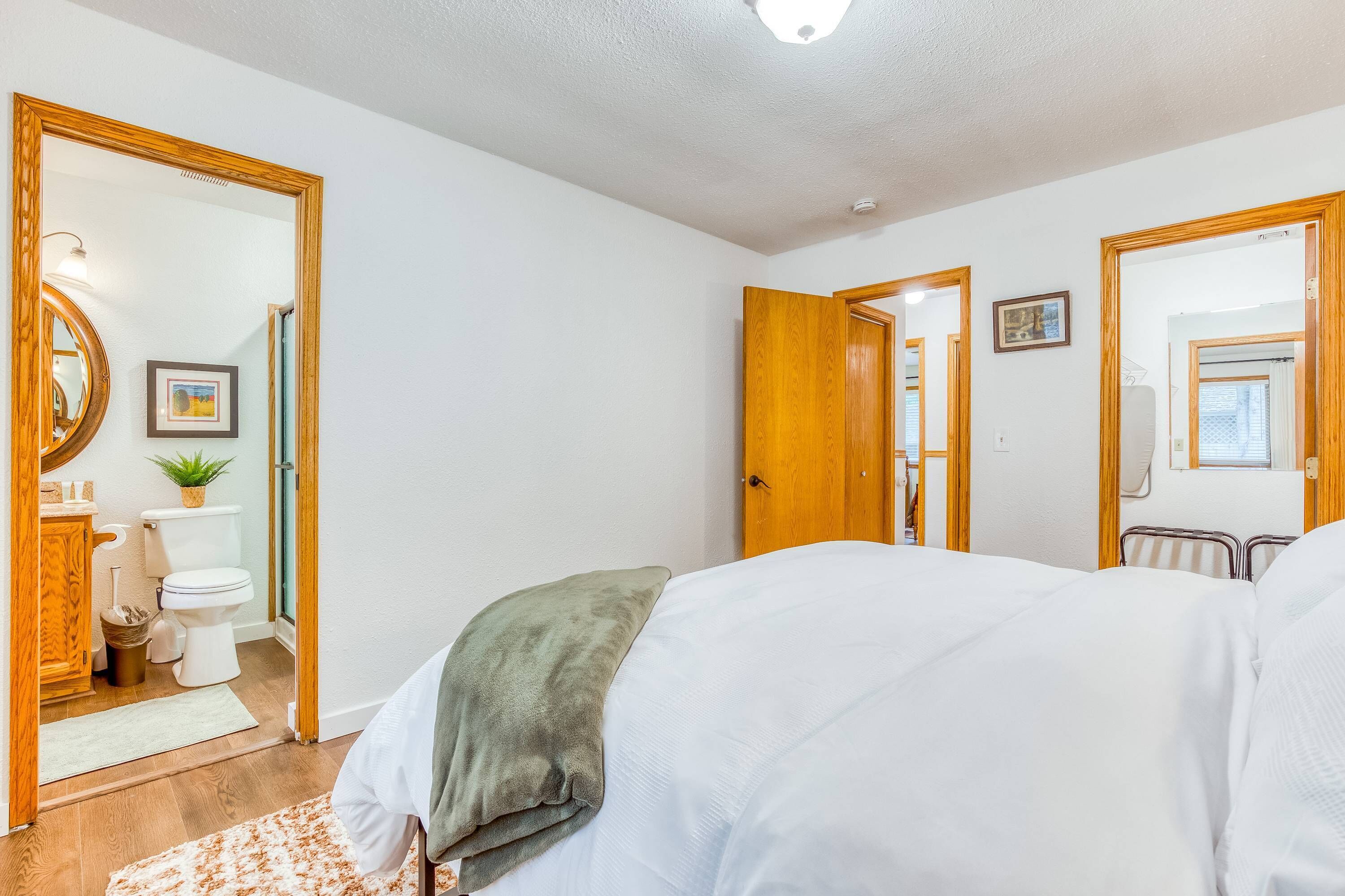 Una camera da letto con un letto, un comodino, uno specchio e una porta che dà su un bagno.