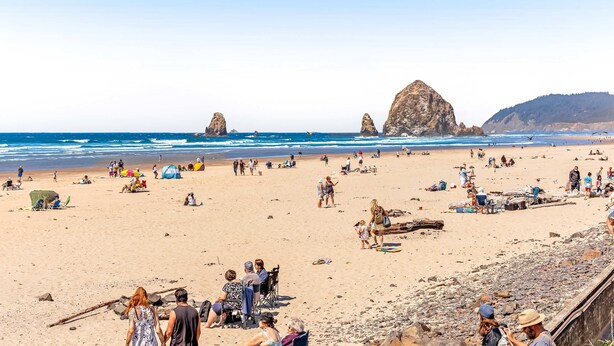 A beach with people, tents, and rocky outcrops. - Spacious home with fenced yard, deck, grill, fast WiFi, & game room (Cannon Beach)