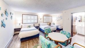 A hotel room with two beds, a dining table, and a kitchenette. - Retro-chic room near beach with fast WiFI - walk to downtown shops & eateries (Bandon)
