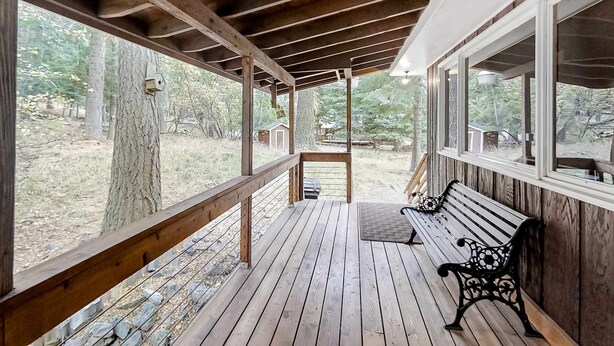 A wooden deck with a bench and a birdhouse. - Large Dog-Friendly Duplex with Lovely Interior + Free WiFi, Private Washer/Dryer (Joseph)