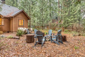 Une cabane dotée d’une terrasse, entourée d’une forêt.