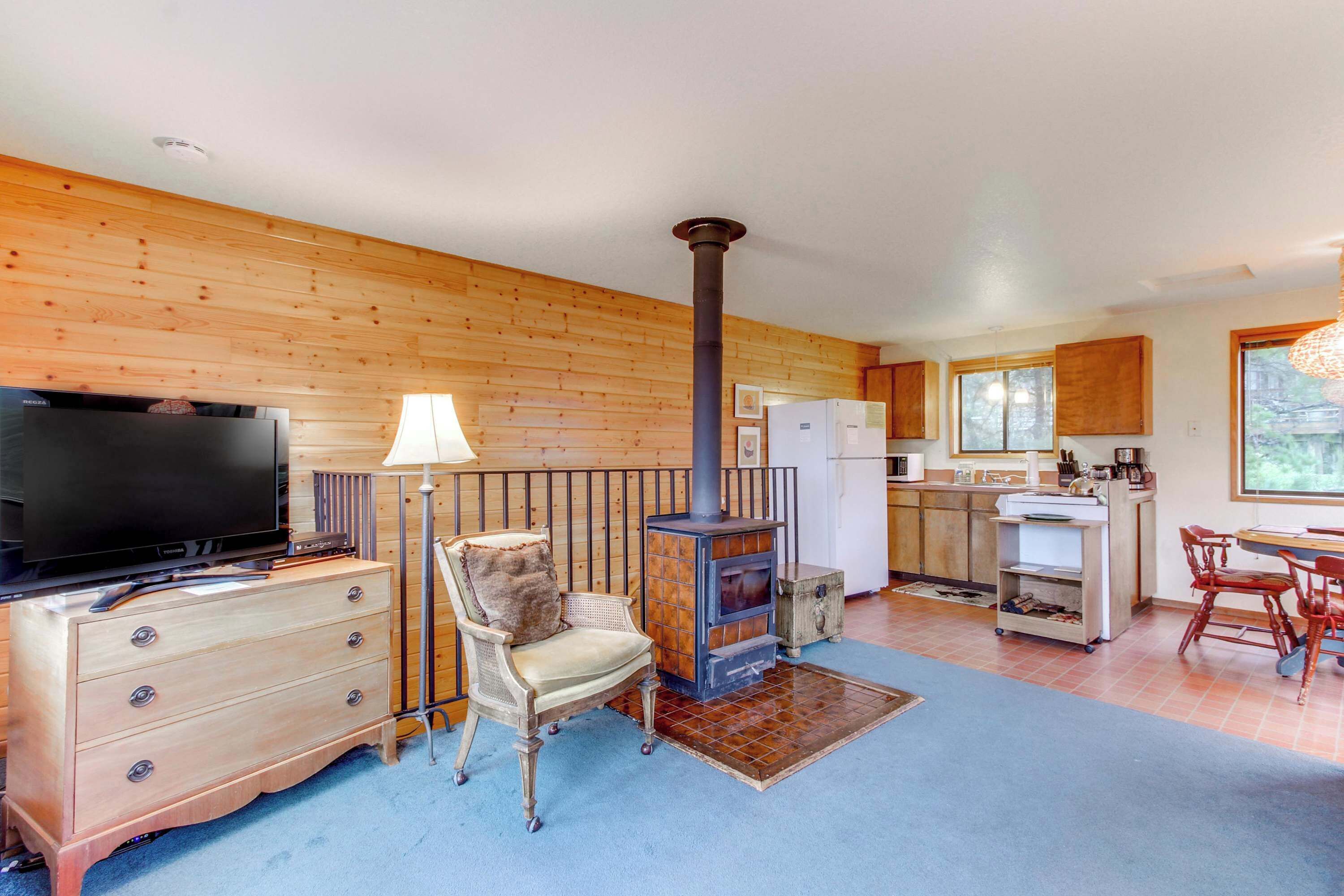 A cozy living room with a television, a fireplace, a dining area, and a kitchen.