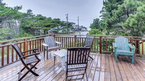 Eine Holzterrasse mit Gartenmöbeln, darunter Stühle und ein Tisch.