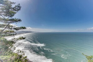 Eine Küstenlandschaft mit blauem Himmel, Sandstrand und ruhiger See.