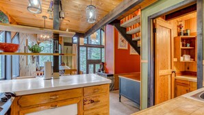 Una cucina con pensili in legno, un piano di lavoro bianco e lampade a sospensione.