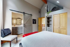 A bedroom with a bed, a bench, a sliding door, and a wardrobe. - Beautifully updated, golf-course-front chalet with deck, pools, hot tubs & gyms (Eagle Crest)