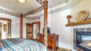 Ein Schlafzimmer mit einem Himmelbett, einem Kamin, einem Schminktisch und einem Spiegel.