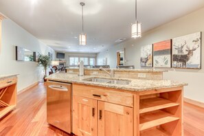 A spacious kitchen with granite countertops, wooden cabinets, and pendant lighting. - Terrific Mt Hood condo with gas fireplace, balcony view & shared pool & hot tub (Government Camp)